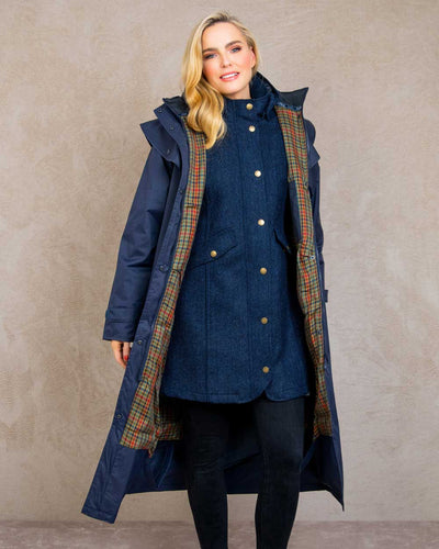 Heritage Navy coloured Jack Murphy Malvern Ladies Waterproof Bush Coat on wall background #colour_heritage-navy