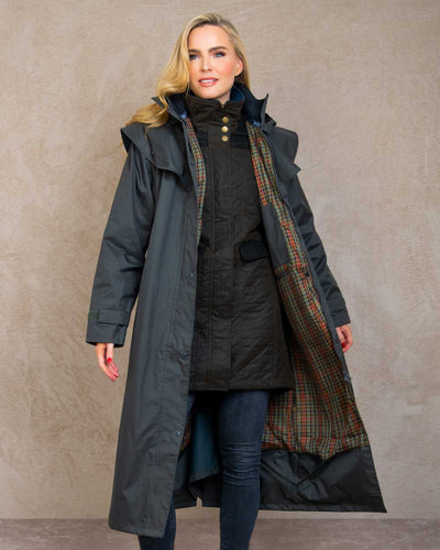 Olive coloured Jack Murphy Malvern Ladies Waterproof Bush Coat on wall background #colour_olive