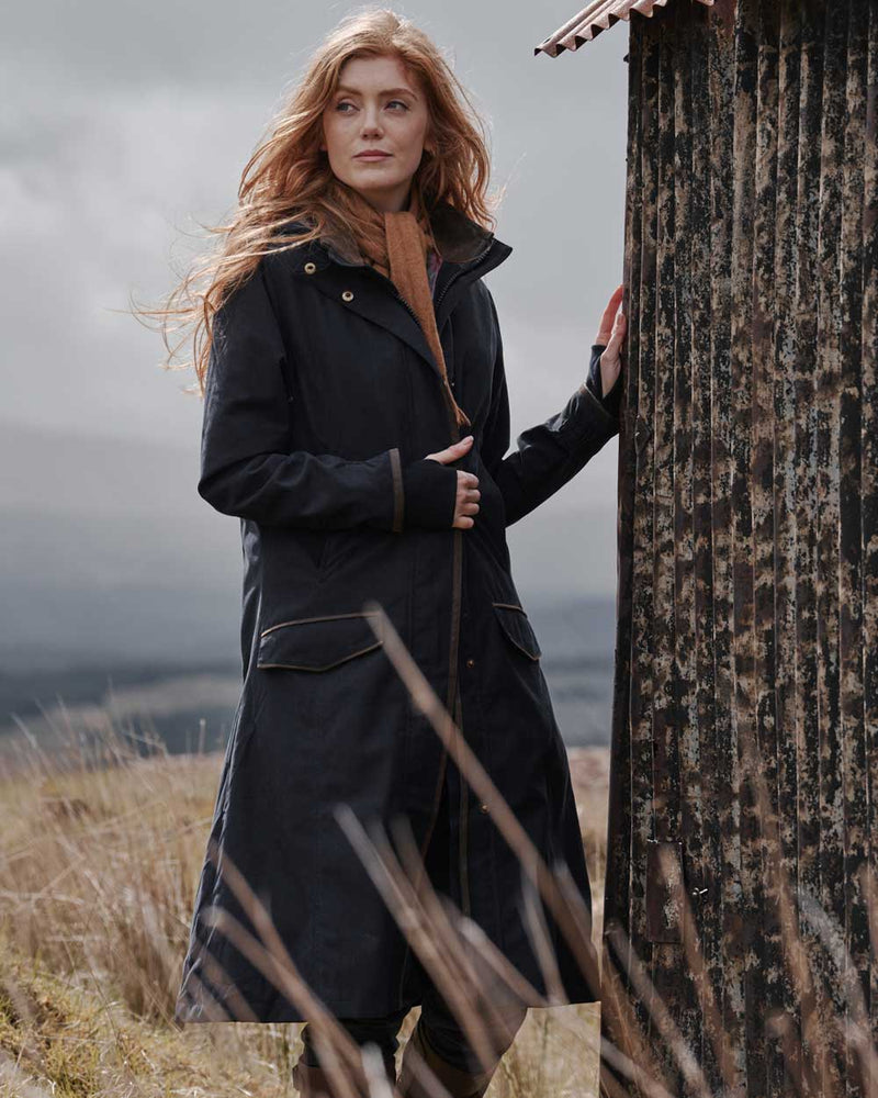 Navy coloured Hoggs of Fife Struther Ladies Long Riding Coat on grassy background 