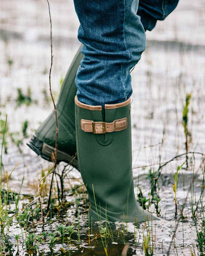 Olive Night coloured Ariat Men's Burford Wellington Boots on mud background #colour_olive-night