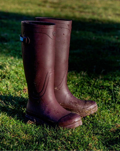 Maroon coloured Ariat Womens Kelmarsh Wellington Boots on Country Grassy background #colour_maroon