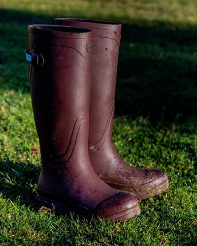 Maroon coloured Ariat Womens Kelmarsh Wellington Boots on Grassy background #colour_maroon