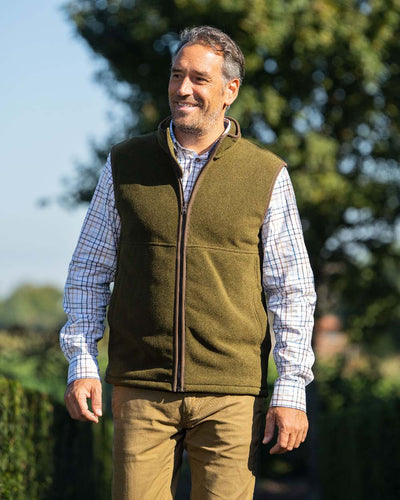 Olive Coloured Baleno Harvey Fleece Gilet on blurry background #colour_olive