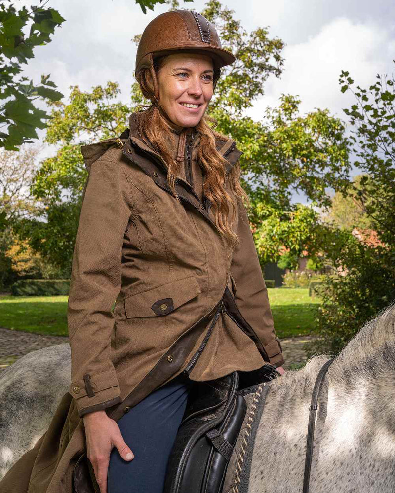 Camel Coloured Baleno Kensington Long Waterproof Coat On A Countryside Background 