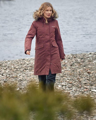 Old Rust Coloured Didriksons Erika Ladies Padded Waterproof Parka 3 On A Coastal Background #colour_old-rust