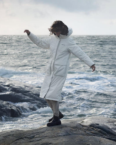 White Foam Coloured Didriksons Leya Womens Parka Long 3 On A Coastal Background #colour_white-foam