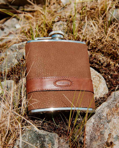 Walnut coloured Dubarry Rugby Hip Flask on rock background #colour_walnut