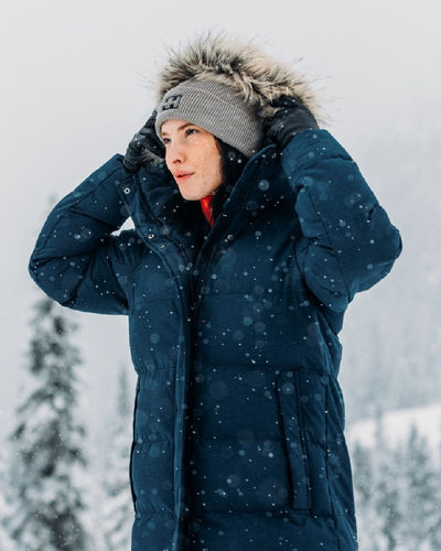 Navy Coloured Helly Hansen Womens Blossom Puffy Winter Parka on snow background #colour_navy