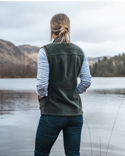 Pine Green Coloured Hoggs of Fife Stenton Ladies Fleece Gilet on lake background #colour_pine-green