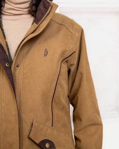 Camel coloured Jack Murphy Erin Long Waterproof Coat on wall background #colour_camel