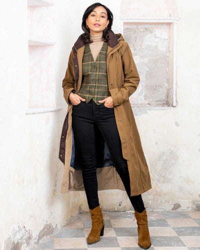 Camel coloured Jack Murphy Erin Long Waterproof Coat on wall background #colour_camel