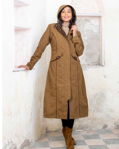 Camel coloured Jack Murphy Erin Long Waterproof Coat on wall background #colour_camel