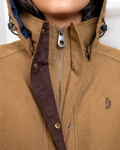 Camel coloured Jack Murphy Erin Long Waterproof Coat on wall background #colour_camel