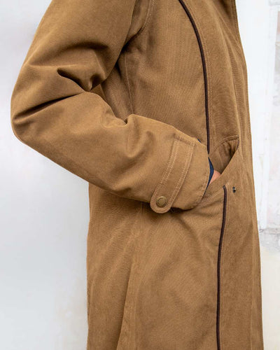 Camel coloured Jack Murphy Erin Long Waterproof Coat on wall background #colour_camel