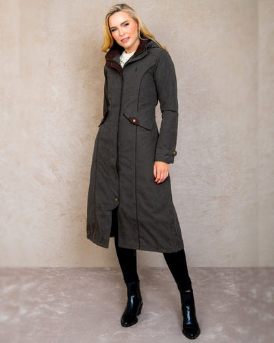 Olive coloured Jack Murphy Erin Long Waterproof Coat on wall background #colour_olive