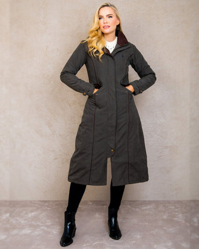 Olive coloured Jack Murphy Erin Long Waterproof Coat on wall background #colour_olive