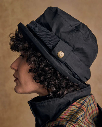 Black coloured Jack Murphy Malvern Heritage Rain Hat on wall background #colour_black