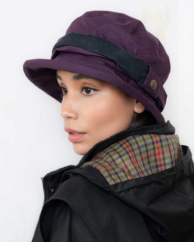 Blackberry coloured Jack Murphy Malvern Heritage Rain Hat on wall background #colour_blackberry