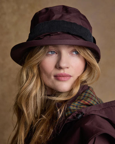 Deep Claret coloured Jack Murphy Malvern Heritage Rain Hat on wall background #colour_deep-claret