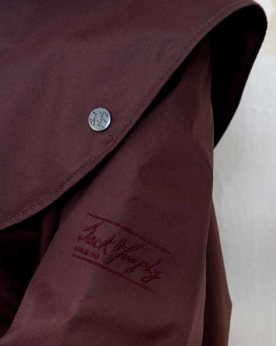 Deep Claret coloured Jack Murphy Malvern Ladies Waterproof Bush Coat on wall background #colour_deep-claret