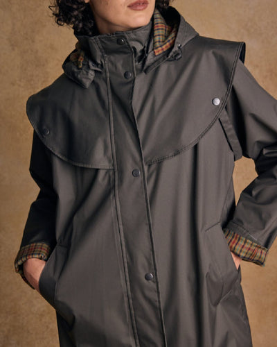 Olive coloured Jack Murphy Malvern Ladies Waterproof Bush Coat on wall background #colour_olive