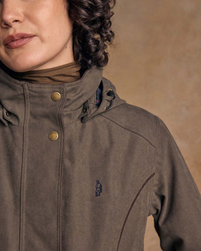 Olive coloured Jack Murphy Una 3/4 Waterproof Coat on wall background #colour_olive