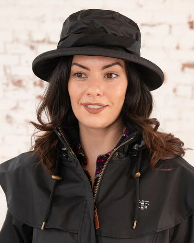 Black coloured Lighthouse Canterbury Waterproof Hat on wall background #colour_black