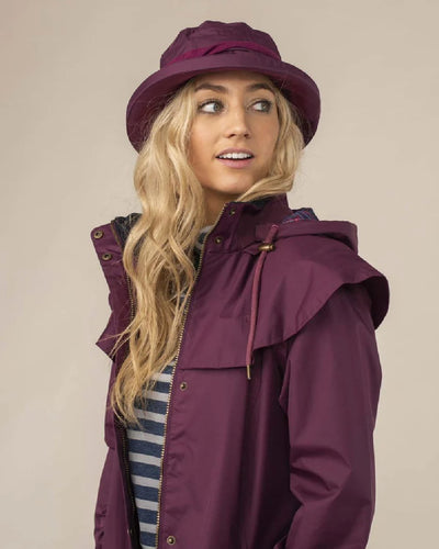 Plum coloured Lighthouse Canterbury Waterproof Hat on wall background #colour_plum