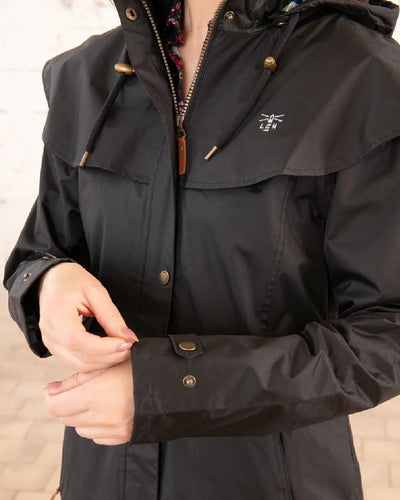 Black Lighthouse Outback Full Length Ladies Waterproof Raincoat on wall background #colour_black