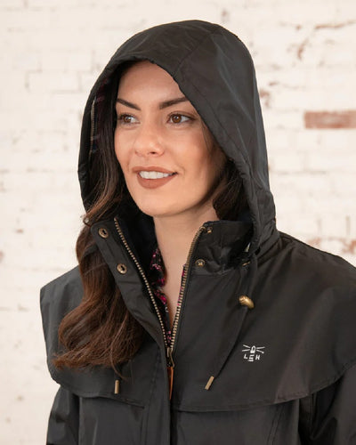 Black Lighthouse Outback Full Length Ladies Waterproof Raincoat on wall background #colour_black