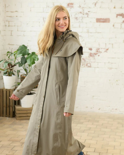 Fawn Lighthouse Outback Full Length Ladies Waterproof Raincoat on wall background #colour_fawn