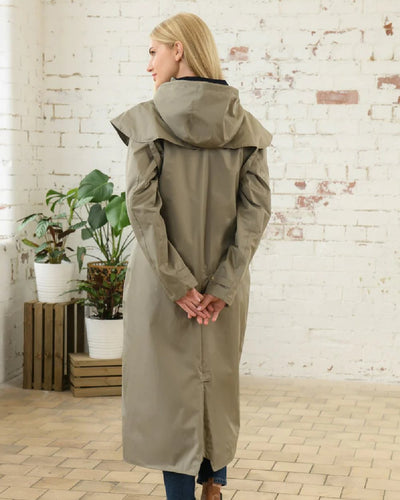 Fawn Lighthouse Outback Full Length Ladies Waterproof Raincoat on wall background #colour_fawn