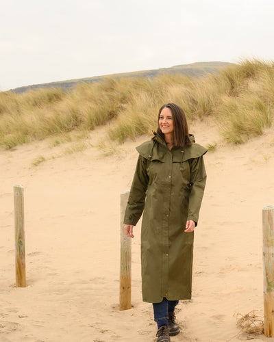 Fern Lighthouse Outback Full Length Ladies Waterproof Raincoat on beach background #colour_fern