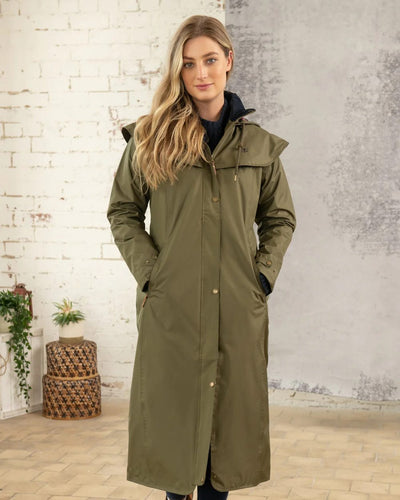 Fern Lighthouse Outback Full Length Ladies Waterproof Raincoat on wall background #colour_fern