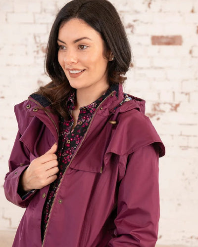 Plum coloured Lighthouse Outback Full Length Ladies Waterproof Raincoat on wall background #colour_plum