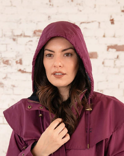 Plum coloured Lighthouse Outback Full Length Ladies Waterproof Raincoat on wall background #colour_plum