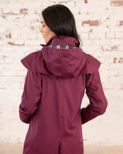 Plum coloured Lighthouse Outback Full Length Ladies Waterproof Raincoat on wall background #colour_plum