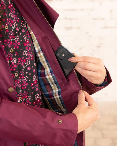 Plum coloured Lighthouse Outback Full Length Ladies Waterproof Raincoat on wall background #colour_plum