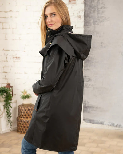 Black coloured Lighthouse Outrider 3/4 Length Ladies Waterproof Raincoat on wall background #colour_black