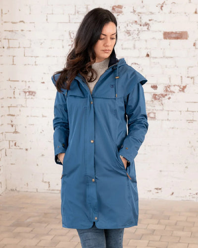 Deep Sea coloured Lighthouse Outrider 3/4 Length Ladies Waterproof Raincoat on wall background #colour_deep-sea