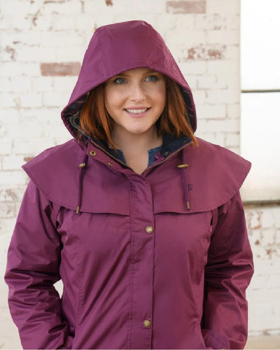 Plum coloured Lighthouse Outrider 3/4 Length Ladies Waterproof Raincoat on wall background #colour_plum