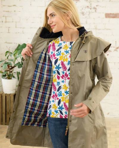 Fawn coloured Lighthouse Outrider 3/4 Length Ladies Waterproof Raincoat on wall background #colour_fawn