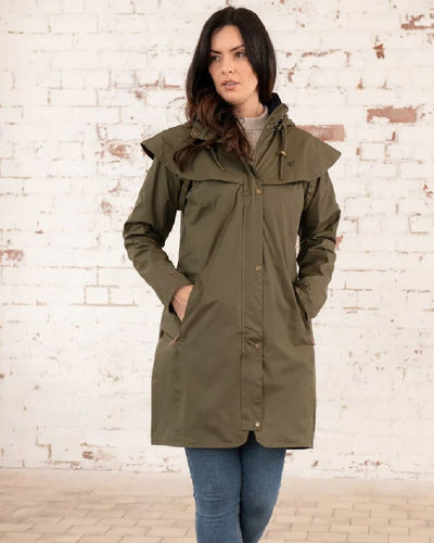 Fern coloured Lighthouse Outrider 3/4 Length Ladies Waterproof Raincoat on wall background #colour_fern