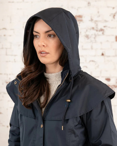 Nightshade coloured Lighthouse Outrider 3/4 Length Ladies Waterproof Raincoat on wall background #colour_nightshade