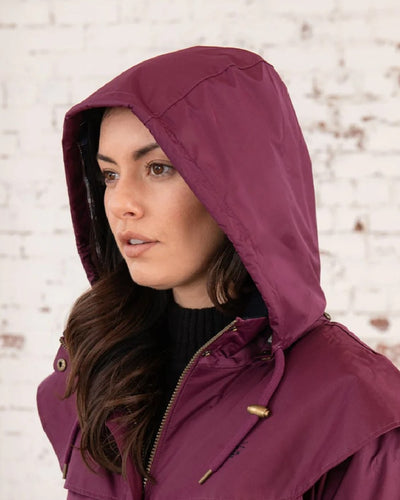 Plum coloured Lighthouse Outrider 3/4 Length Ladies Waterproof Raincoat on wall background #colour_plum