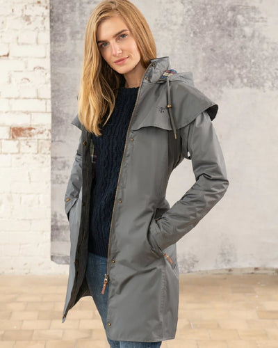 Urban Grey coloured Lighthouse Outrider 3/4 Length Ladies Waterproof Raincoat on wall background #colour_urban-grey