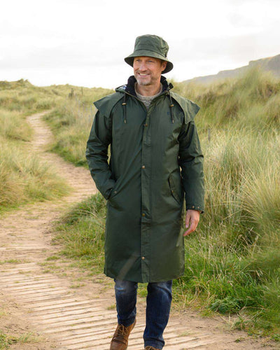 Duffel coloured Lighthouse Long Waterproof Coat on wood walk background #colour_duffel