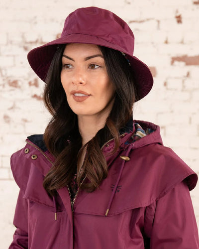 Plum coloured Lighthouse Storm Waterproof Hat on wall background #colour_plum