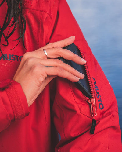 Red coloured Musto Ladies Sardinia Long Rain Jacket on sky background #colour_red