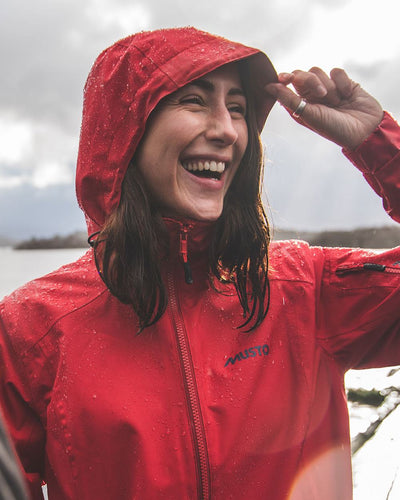 Red coloured Musto Ladies Sardinia Long Rain Jacket on sky background #colour_red